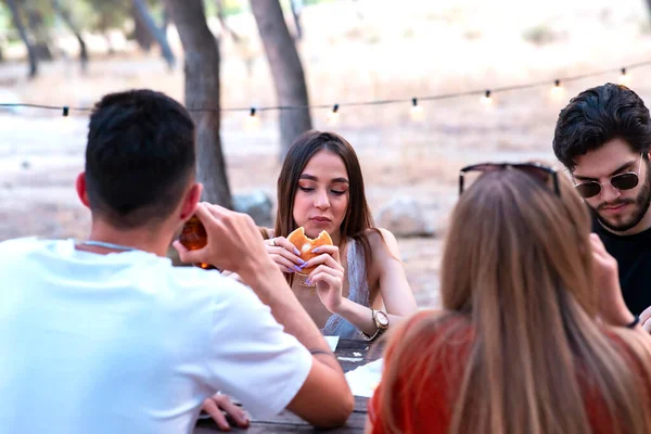 girl eating hamburger with friends
