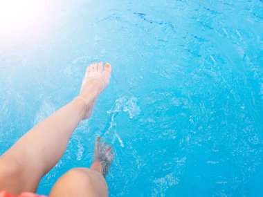 Suda hareket eden bir kızın ayakları