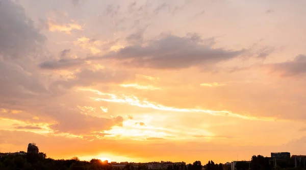 sunset in a city with clouds