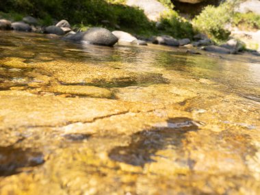 Taşlar ve güneş ışınları altındaki su