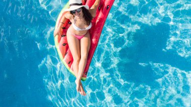 Havuzda şapkalı bir kadın.