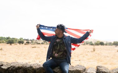 Amerika bayrağı taşıyan genç bir adam.