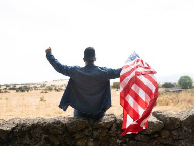 Amerika bayrağı taşıyan genç bir adam.