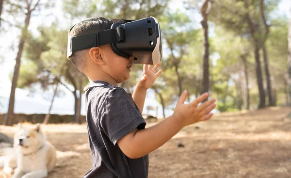 boy with virtual reality glasses in the forest