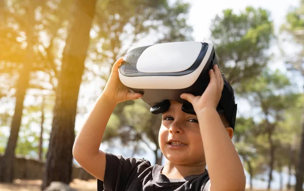 boy with virtual reality glasses in the forest