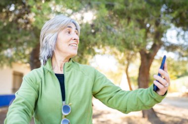 Parktaki son sınıf öğrencisi, akıllı telefon ve bisiklet kullanıyor.