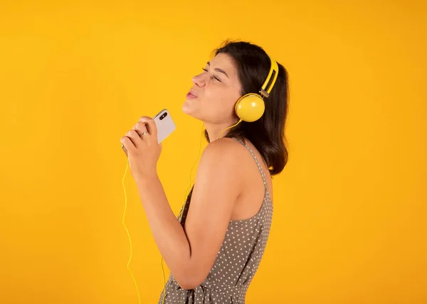 Mujer Escucha Música Con Auriculares Amarillos Fondo Amarillo — Foto de Stock