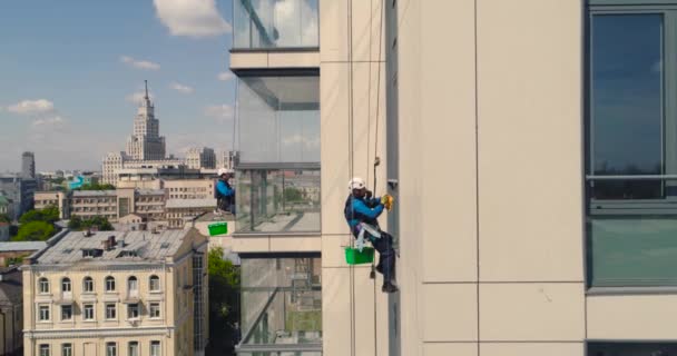 Fensterputzer an einem Bürogebäude. Industriekletterer - Fassadenreinigung. Luftbilddrohne — Stockvideo