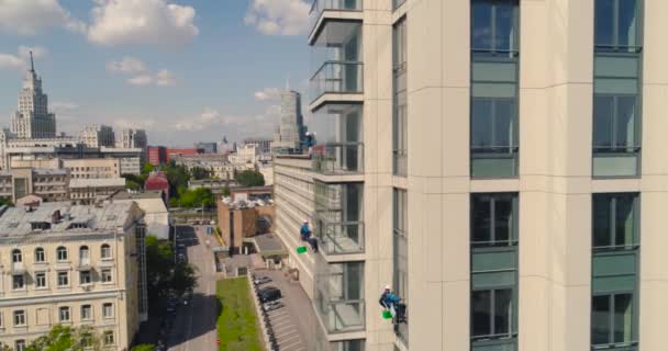 Fensterputzer an einem Bürogebäude. Industriekletterer - Fassadenreinigung. Luftbilddrohne — Stockvideo