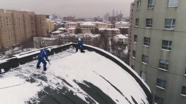 Den industriella klättrare avmarkera ett tak från ackumulerade snön i Moskva. Antenn. — Stockvideo