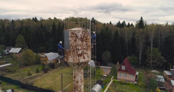 Industrial climbers paint the iron tower. Risky job. Extreme work. Worker alpinist. — Stock Video