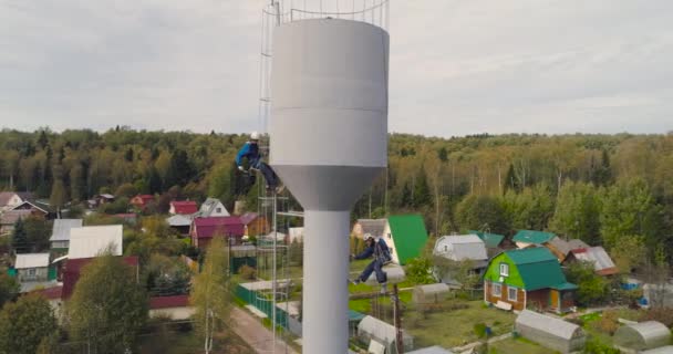 Industri klättrare måla järn tornet. Riskabelt jobb. Extrem arbete. Arbetaralpinist. — Stockvideo