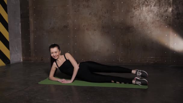 Stretching in de sportschool op een yoga mat — Stockvideo