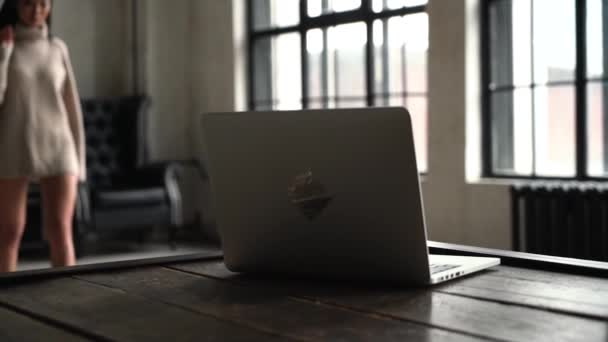 Una mujer atractiva trabajando en su computadora en un sofá, en cámara lenta. Asiática chica se sienta detrás de la lugar de trabajo con un ordenador portátil . — Vídeos de Stock