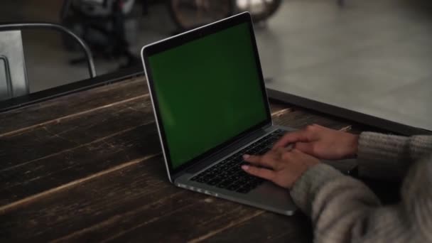 Una donna attraente che lavora al computer su un divano, al rallentatore. Asiatico ragazza si siede dietro il posto di lavoro con un computer portatile . — Video Stock