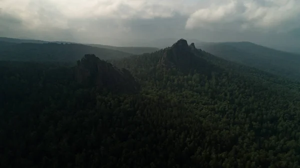 Colonne di pietra giganti dalla montagna. Sole mattutino arancione. Deriva aerea cinematografica drone volo. Bella migliore natura russa — Foto Stock