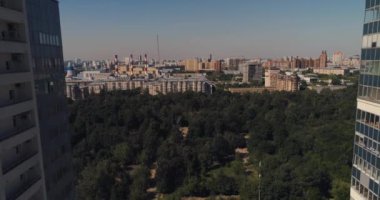 Yeni modern konutların, parklı gökdelenlerin ve bir sürü ağaçların arasında insansız hava aracı uçuşu.