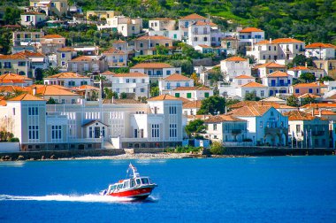 Küçük kırmızı motorlu tekne insanları Yunanistan 'ın Spetses adasına naklediyor