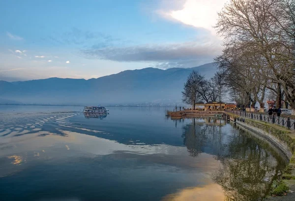 Yanya şehir ve göl Pamvotis gün batımı. denize sıfır arabalar, yayalar ve bisikletler için sokak. Epirus, Yunanistan.