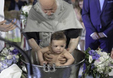 Atina, Yunanistan-28 Şubat 2019: Hıristiyan kilisesinde vaftiz yenidoğan bebeğinin ayin kutsal Ortodoks ritüsi.