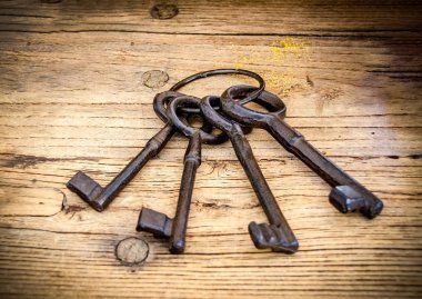 Paslı antika anahtar taşı arka plan olarak ahşap masa üstünde