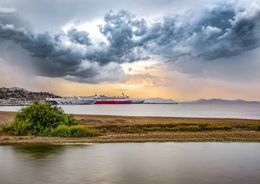 Gün batımında dramatik bir gökyüzü altında Rafina şehir ve liman görünümü 