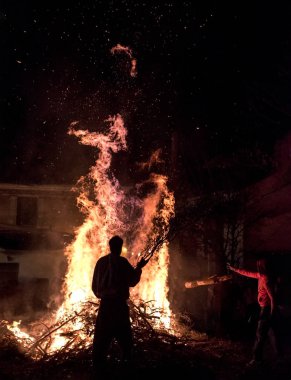 İnsanlar bir Yunan köyde bir şenlik ateşi etrafında St John's Eve kutlamak