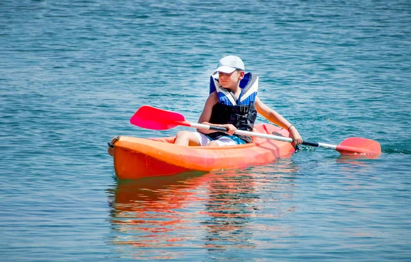 kayaking lessons. Boy with life buoy suit in kayak lessons during summer vacations in an island of Greece.