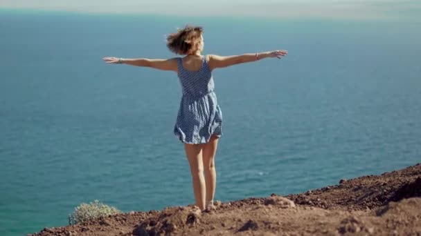 Achteraanzicht van vrolijke jonge vrouw met handen omhoog. Vrijheid concept. — Stockvideo
