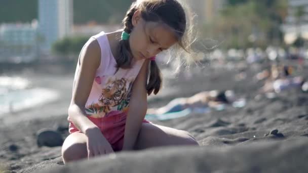 Χαριτωμένο κορίτσι που παίζει με άμμο στην παραλία. Θερινή ώρα — Αρχείο Βίντεο