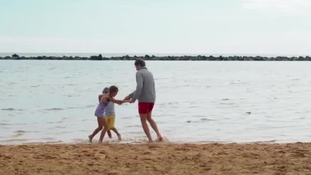 Πατέρας, γιος και κόρη διασκεδάζουν μαζί, χορεύοντας και πηδώντας. Θερινή ώρα — Αρχείο Βίντεο