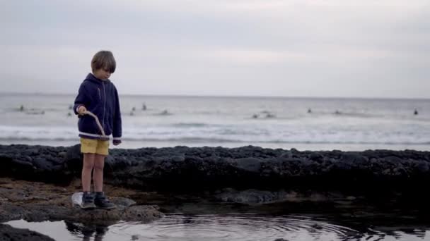 Niño pequeño está pescando en el océano en un día de verano — Vídeos de Stock