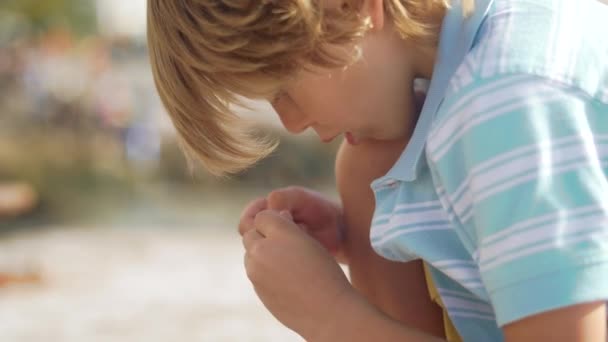 Niño pequeño esculpe de plastilina al aire libre, vista de cerca. Hora de verano — Vídeo de stock