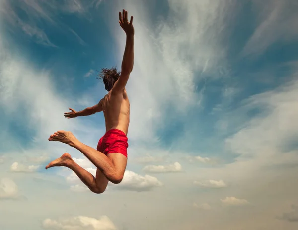 Homem a saltar sobre o céu nublado. Estilo de vida divertido verão — Fotografia de Stock