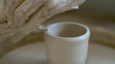 Seramik üretimi. İnsan çömlek çarkında çamurdan heykel yapar.