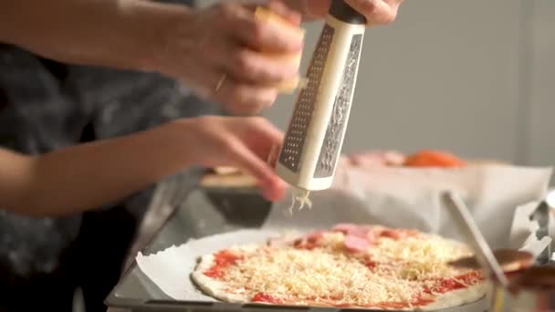 Děti vaří pizzu. Chlapec a dívka se baví s otcem. Preperační přísady na pizzu. — Stock video