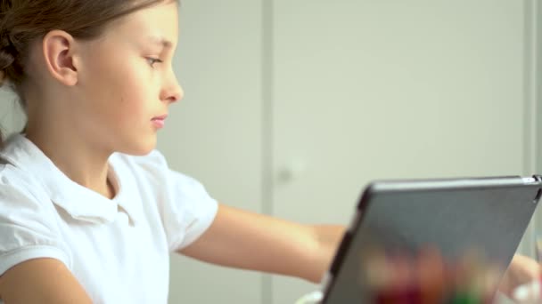 Tatlı çocuk eğitim için dizüstü bilgisayar kullanıyor, online öğrenim görüyor, evde eğitim görüyor. Kızın evde ödevi var.. — Stok video