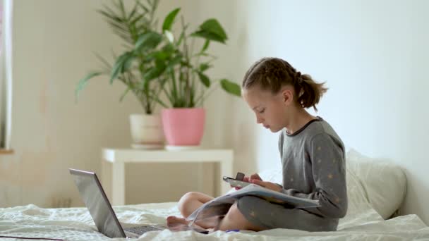 Anak lucu menggunakan laptop untuk pendidikan, studi online, belajar di rumah. Gadis memiliki pekerjaan rumah di sekolah rumah. — Stok Video