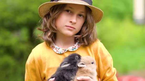 Schattig meisje dat met echt konijn speelt. Kinderen spelen met huisdieren. — Stockvideo