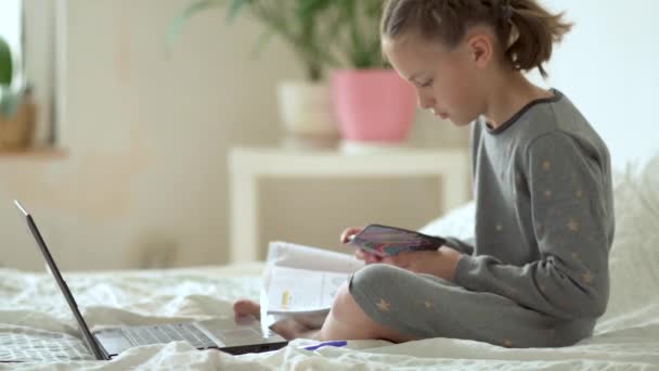 Nettes Kind nutzt Laptop für Bildung, Online-Studium, zu Hause studieren. Mädchen haben Hausaufgaben zu Hause. — Stockvideo