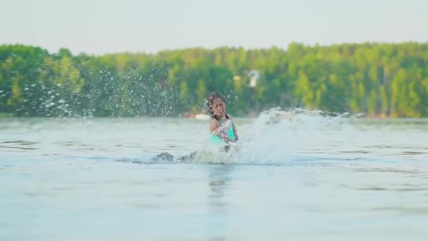 Šťastné dítě si hraje v jezeře. Kluk se baví na pláži. Letní dovolená — Stock video