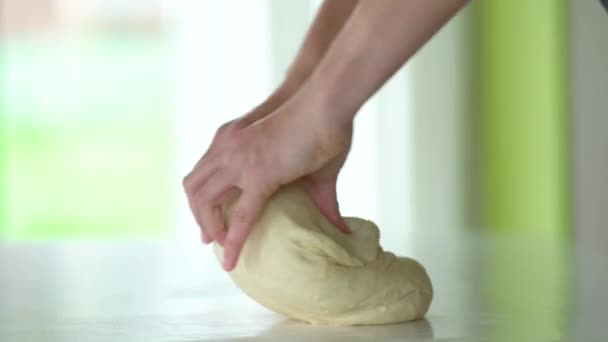 Detailní záběr rukou šéfkuchaře, jak hnětají syrové těsto na stole. Koncept pečení — Stock video