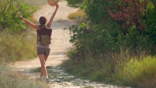Mujer con mochila caminando sola en la carretera en las montañas. Viajes estilo de vida concepto aventura al aire libre vacaciones de verano — Vídeos de Stock