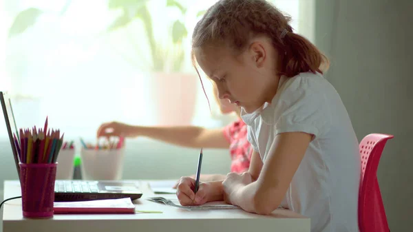 Słodkie dzieci korzystają z laptopa do edukacji, badań online, nauki w domu. Chłopiec i dziewczyna mają pracę domową w nauce na odległość. Koncepcja kształcenia w domu — Zdjęcie stockowe