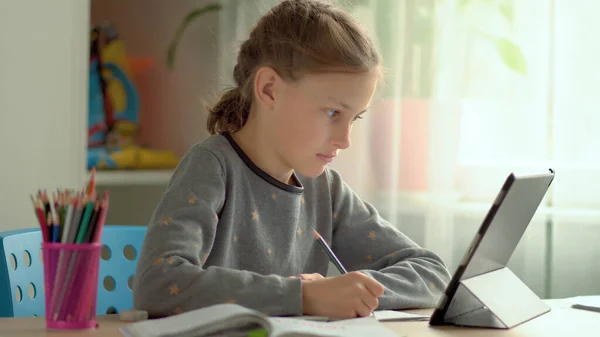 Los niños lindos utilizan el ordenador portátil para la educación, estudio en línea, estudio en casa. La chica tiene tarea en el aprendizaje a distancia. Concepto para la educación en el hogar — Foto de Stock