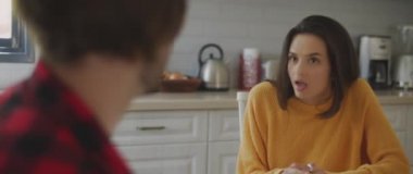 Erkek arkadaşını onu aldatmakla suçlayan bir kadın, evdeki yemek masası için kavga eden bir çift. Ayrılmak, aldatmak, kıskançlık, boşanma kavramı. BMPCC 4K 