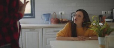 Erkek arkadaşını onu aldatmakla suçlayan bir kadın, evdeki yemek masası için kavga eden bir çift. Ayrılmak, aldatmak, kıskançlık, boşanma kavramı. Sığ DOF, Yavaş çekim, BMPCC 4K