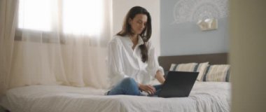 Evden bilgisayarını tamir ederken gülümseyen genç bir kadın. Ağır çekim, BMPCC 4K