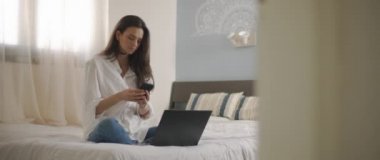 Evden bilgisayarla uğraşırken telefona cevap veren bir kadın. Ağır çekim, BMPCC 4K