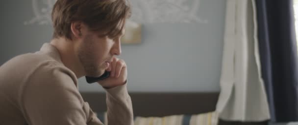 Hombre Hablando Con Alguien Por Teléfono Mientras Trabaja Con Portátil — Vídeos de Stock